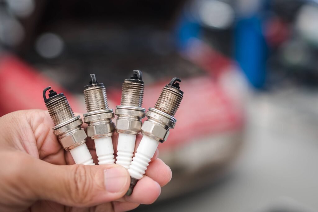 Man holding dirty spark plugs